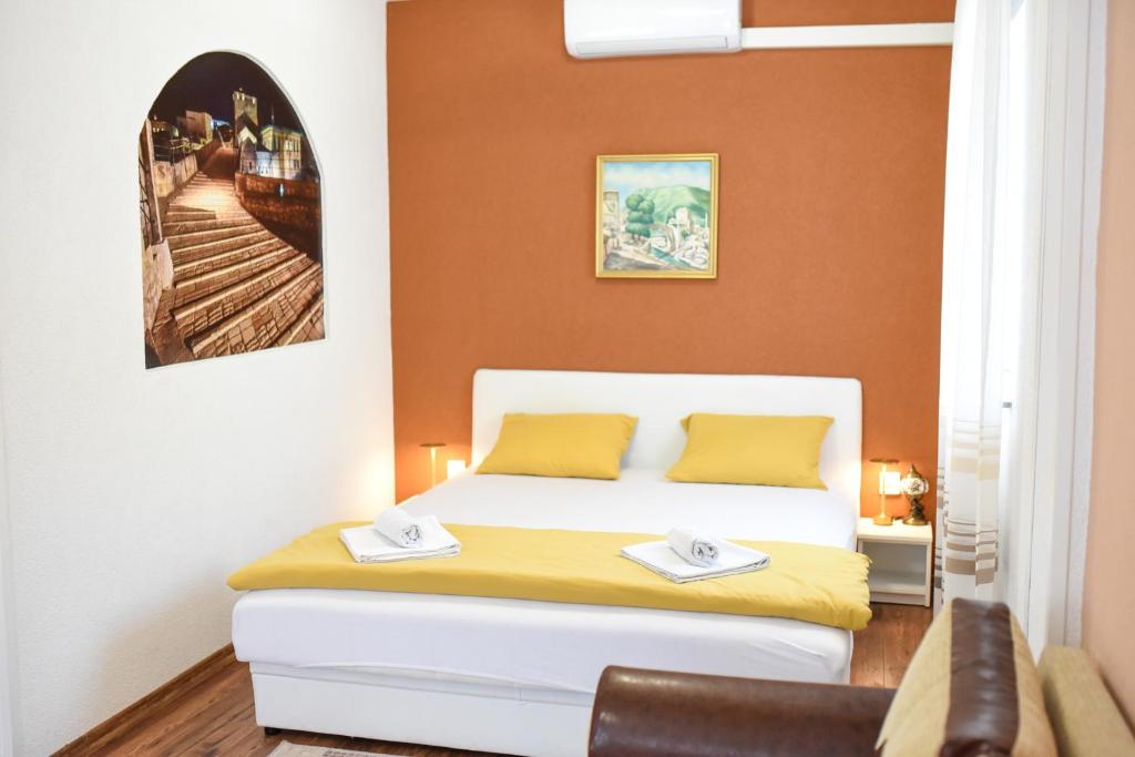 a small bedroom with a bed and a chair at Central Stay Mostar - Apartments & Rooms in Mostar