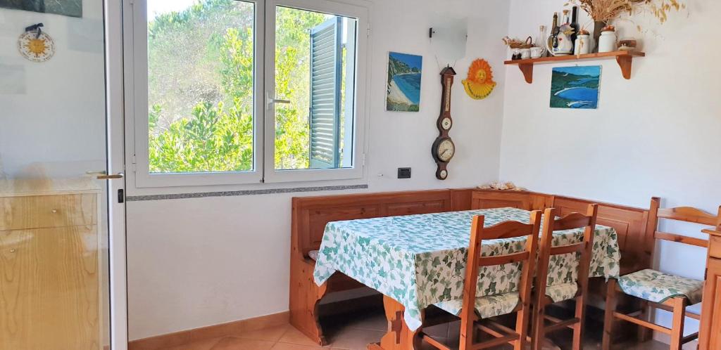 a dining room with a table and chairs and a window at One bedroom apartement at Lacona 100 m away from the beach with enclosed garden in Lacona