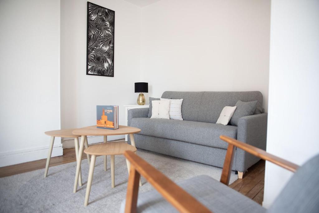 un salon avec un canapé et une table dans l'établissement Appartement Perret, au Havre