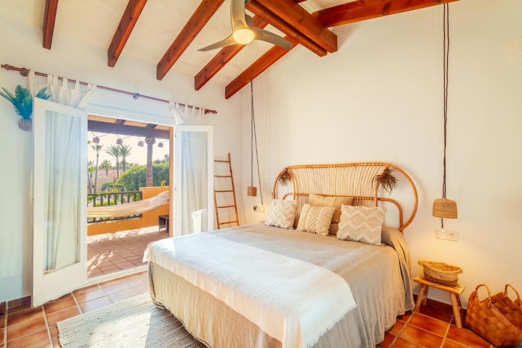 a bedroom with a large bed and a balcony at Ca Nura - Dúplex con piscina y a pasitos del mar in Son Xoriguer