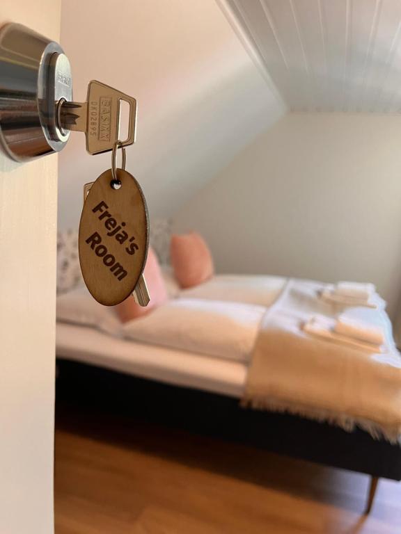 uma chave da porta com uma etiqueta na cama em Jonas Hus - Munkgaard Bed & Breakfast em Store Heddinge