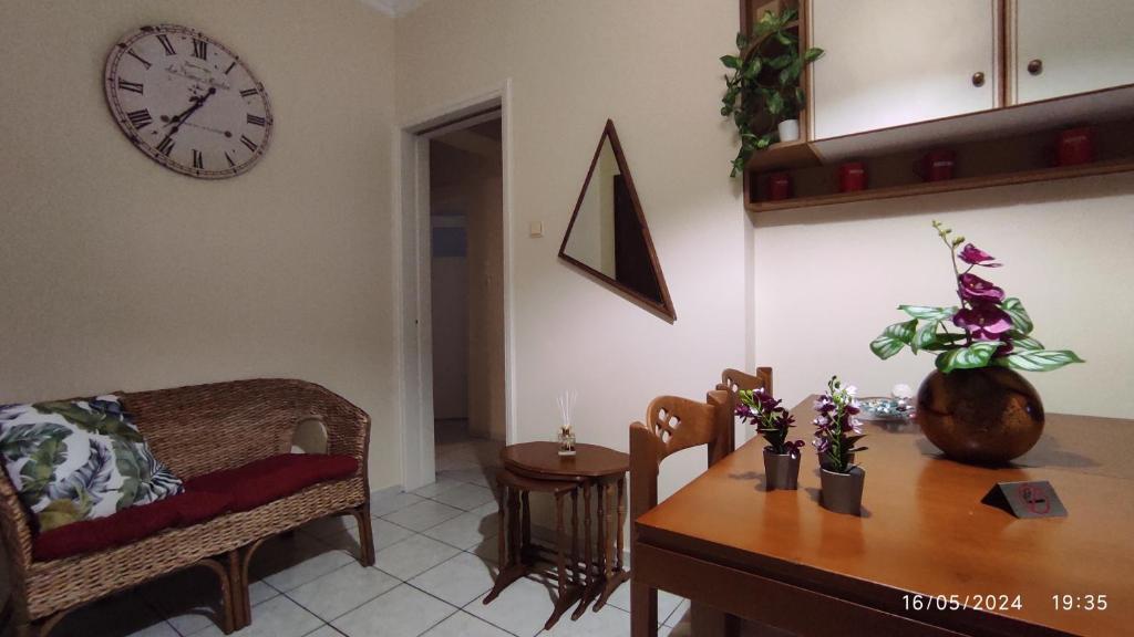 Διαμέρισμα στο Κέντρο της Χίου في خيوس: غرفة معيشة مع طاولة وساعة على الحائط
