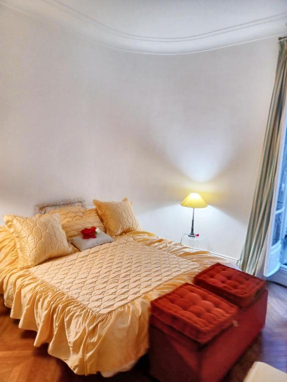 ein Schlafzimmer mit einem großen Bett mit gelber Decke in der Unterkunft Appartement d'une chambre avec wifi a ParisEL in Paris