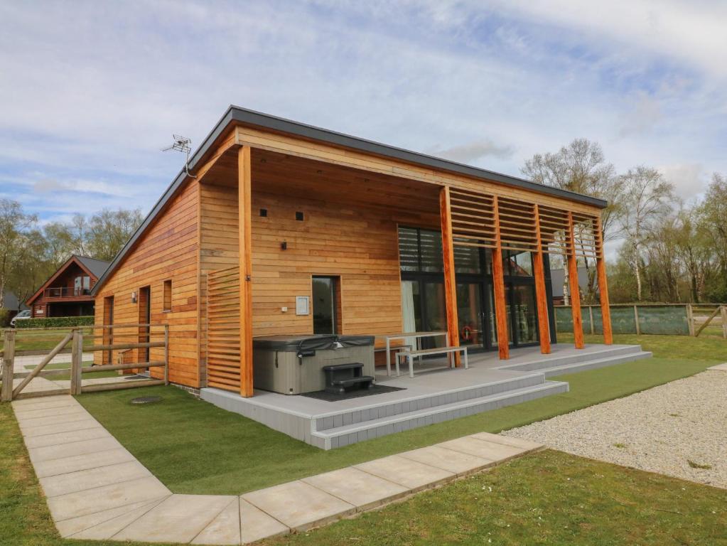a small wooden house with a grill in a yard at Cherry in Winkleigh