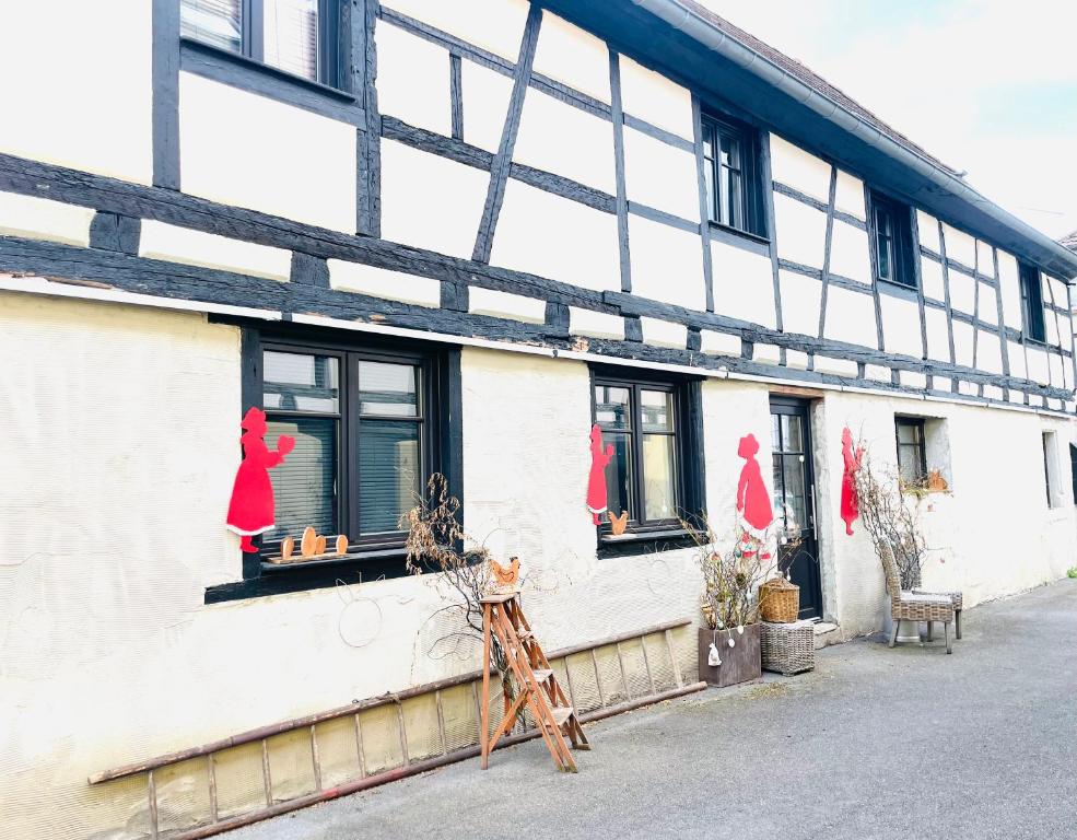 un bâtiment blanc avec des mannequins rouges aux vitrines dans l'établissement Le cœur d'Alsace 2 à 6 pers à 5 min de Ribeauvillé, à Guémar