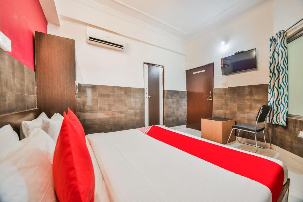 um quarto com uma cama vermelha e branca e uma televisão em OYO 45055 Hotel King's Palace em Kota