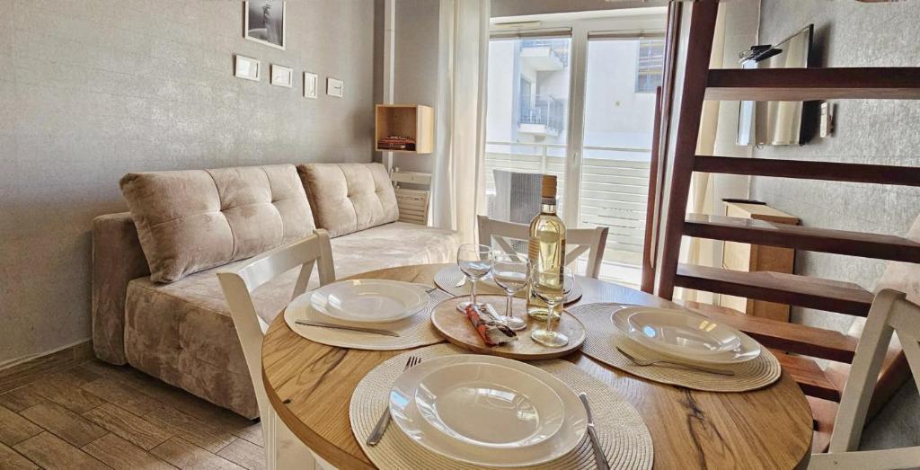 a dining room with a table and a couch at Holiday Home SLAVIA NEW 11 in Międzyzdroje