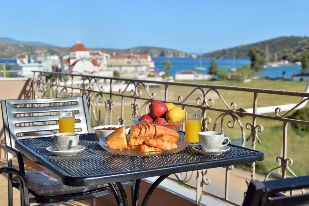 een tafel met een schaal brood en fruit op een balkon bij Stork Apartments in Vivari