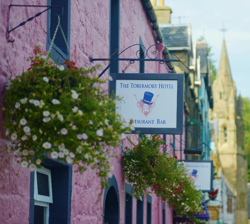 różowy budynek z znakiem dla hotelu torweskiego w obiekcie The Tobermory Hotel w mieście Tobermory