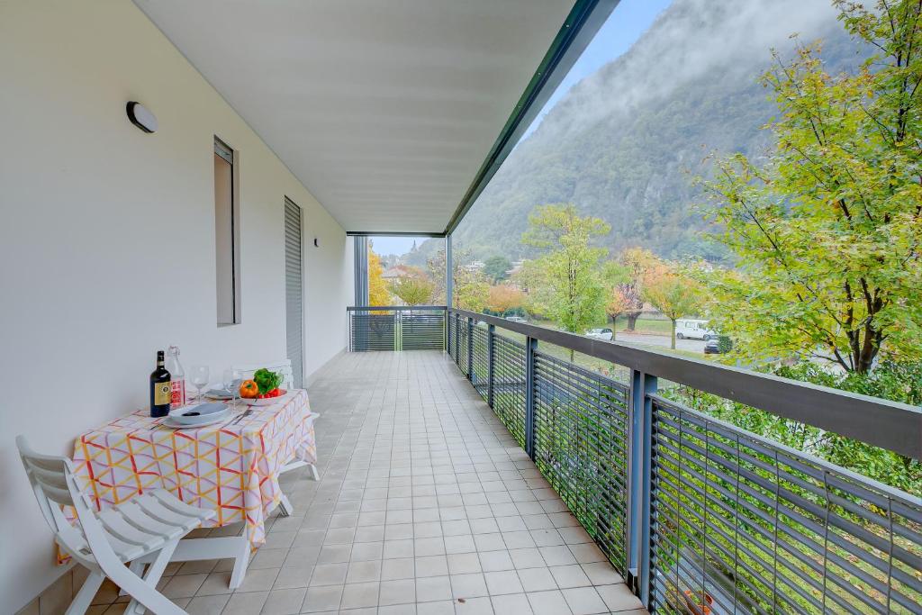 a balcony with a table and a view of a mountain at Magnolia - Happy Rentals in Laveno-Mombello