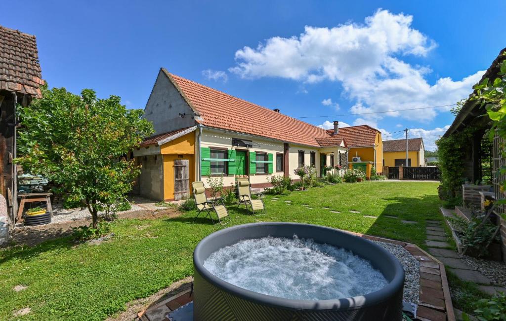 a barrel of water in the yard of a house at Beautiful Home In Hlebine With Jacuzzi in Hlebine