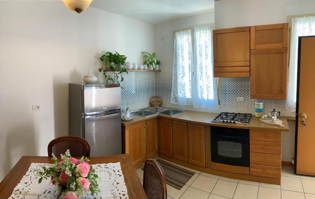 a kitchen with a stainless steel refrigerator and a table at Palazzo Venieri in Lugo