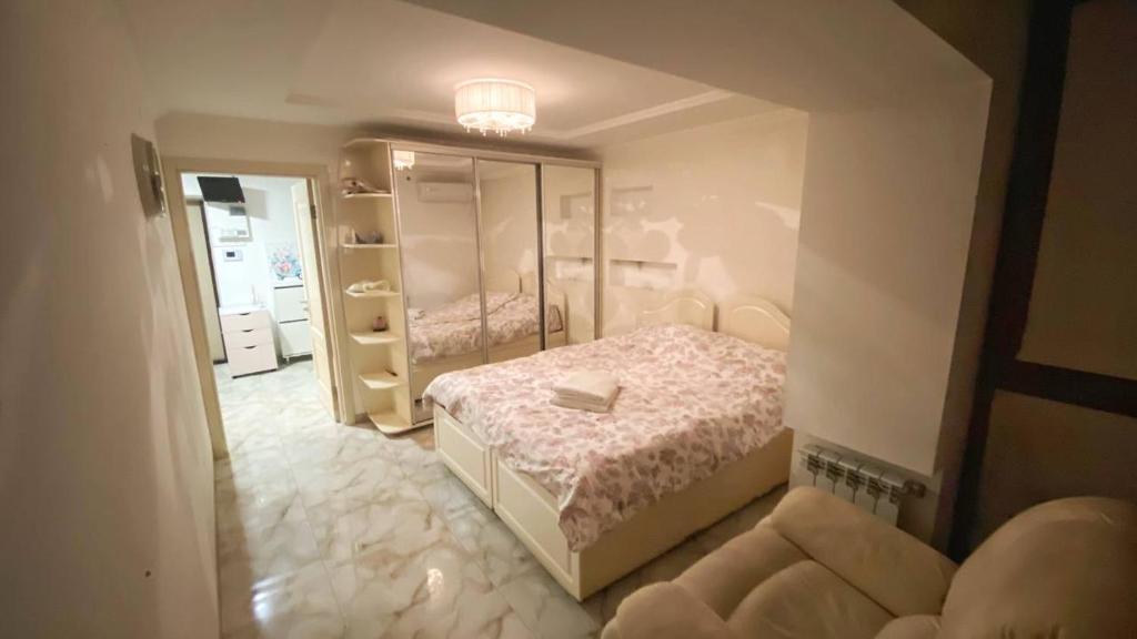 Dormitorio pequeño con cama y espejo en Квартира возле парка Софиевка en Umanʼ