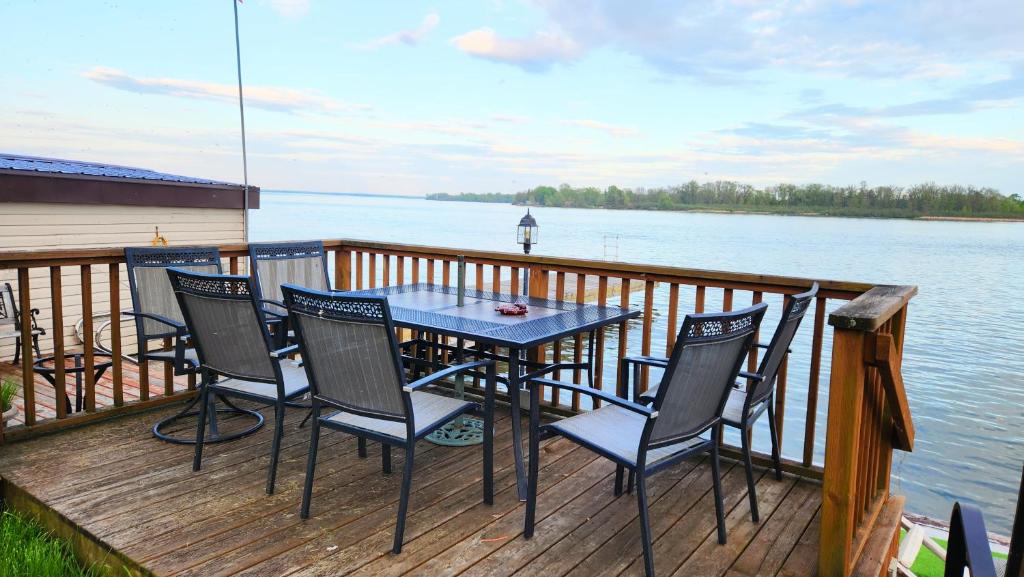 a table and chairs on a deck next to the water at Skylight Waterfront home w/ amazing view/dock/boat in Lancaster
