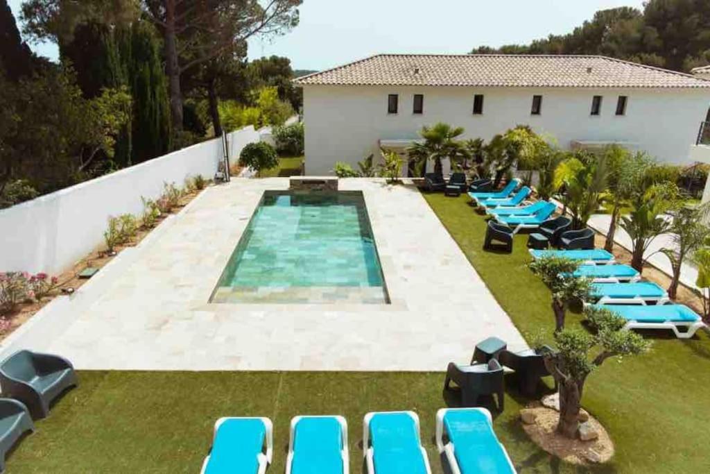 une piscine extérieure avec des chaises longues bleues et un complexe dans l'établissement Villa Marie-Jeanne, à Sanary-sur-Mer