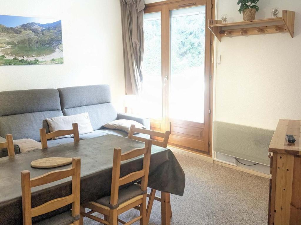 salon z kanapą i stołem w obiekcie Charmant 2 pièces au pied des pistes avec balcon et casier à skis - FR-1-557-78 w mieście Les Adrets