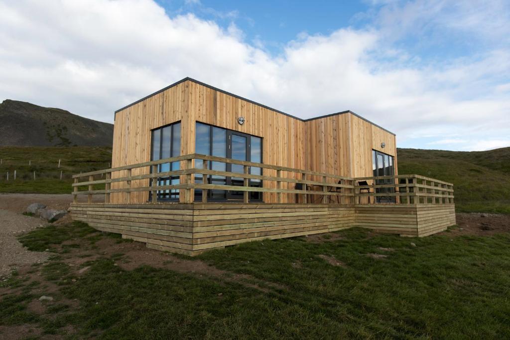 a wooden house on top of a field at Dis Cottages in Grundarfjordur