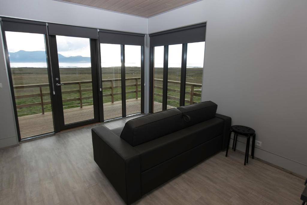 a living room with a couch and large windows at Dis Cottages in Grundarfjordur