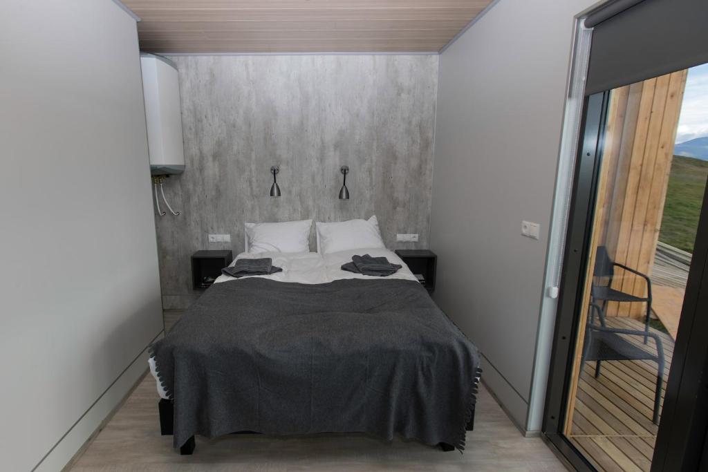 a bedroom with a bed and a large window at Dis Cottages in Grundarfjordur