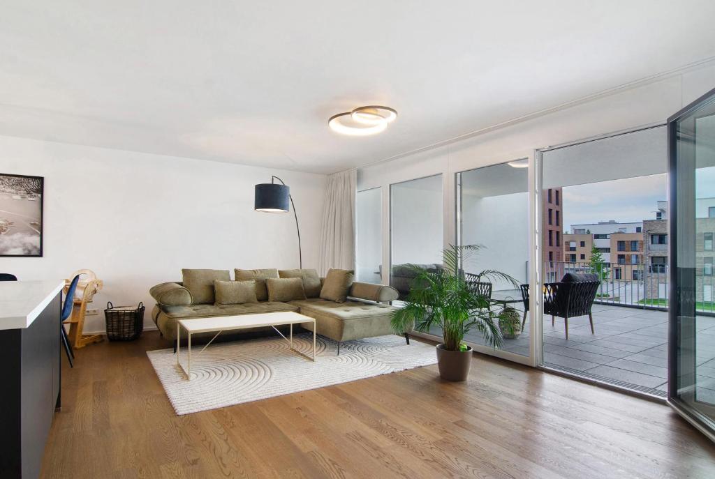 a living room with a couch and a balcony at Neues Apartment am Schloßsee Salem in Salem