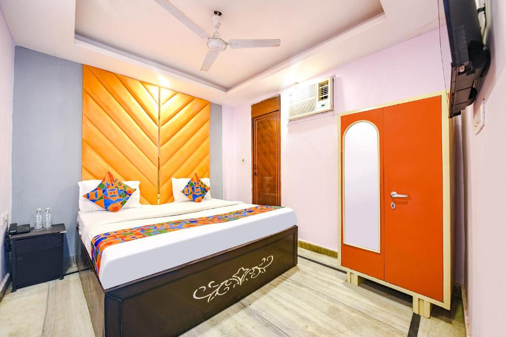 - une chambre avec un lit et une télévision dans l'établissement FabHotel Iris Lite, à New Delhi