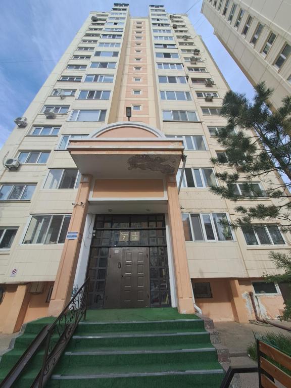 een hoog gebouw met een trap naar een deur bij Квартира на Набережной in Astana