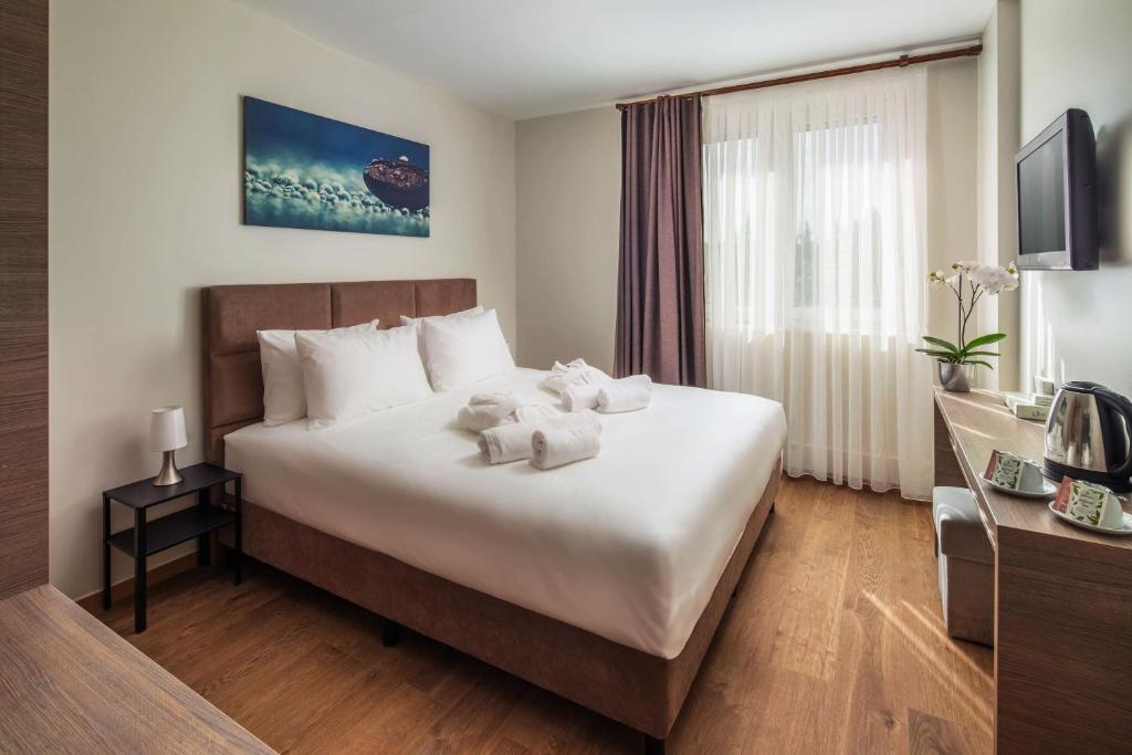 ein Hotelzimmer mit einem Bett mit zwei Teddybären darauf in der Unterkunft Vitta Hotel Superior in Budapest