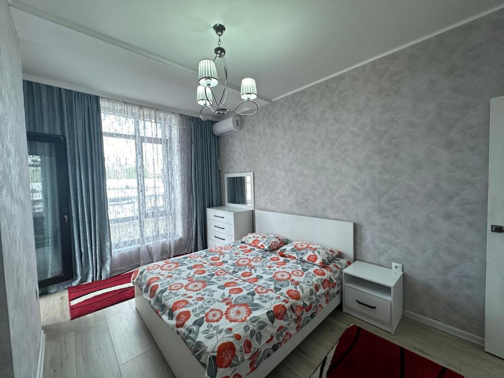 a bedroom with a bed with a floral bedspread at 2bedroom on Diamond City in Bishkek