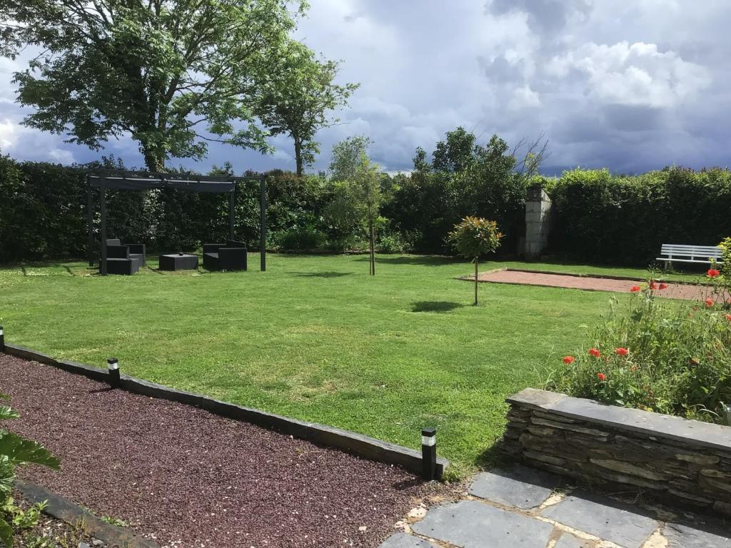 a garden with a park with a bench and grass at Lorali in Gohier