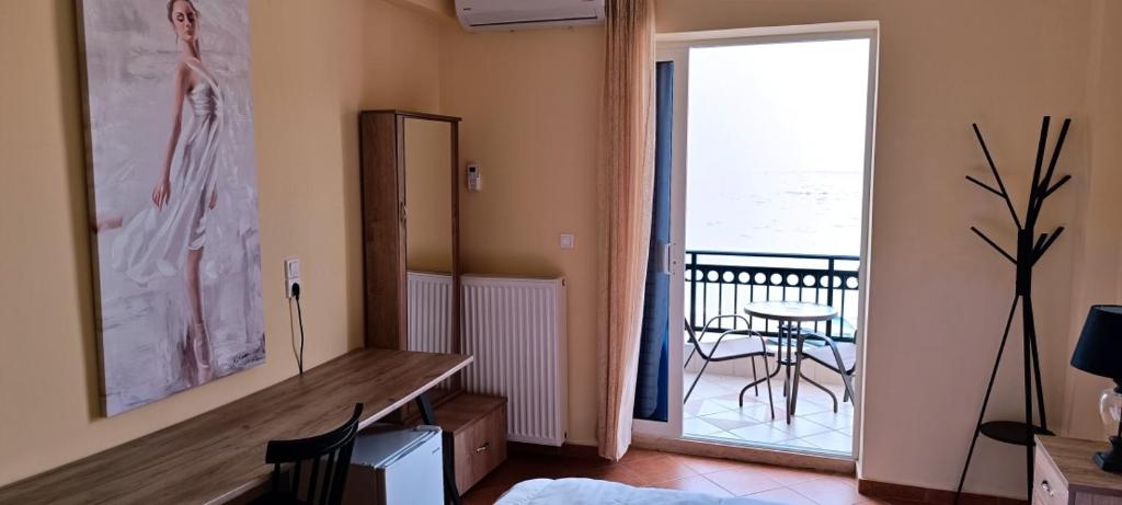uma sala de estar com uma mesa e uma varanda em KAMVISSIS HOTEL em Tyros