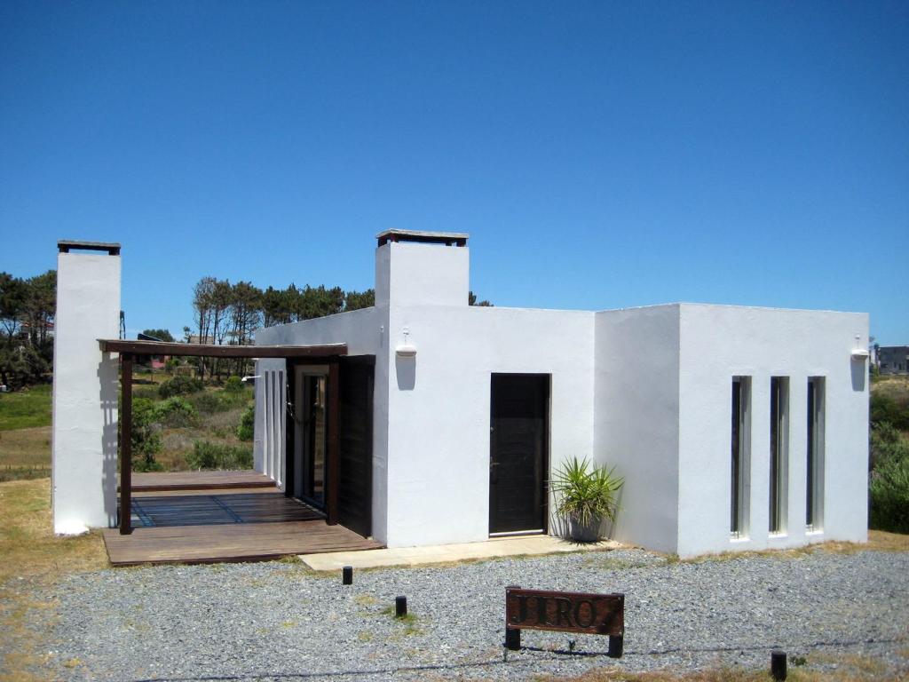 a rendering of a white house with the door open at Casa de Familia Jiro in Punta Del Diablo