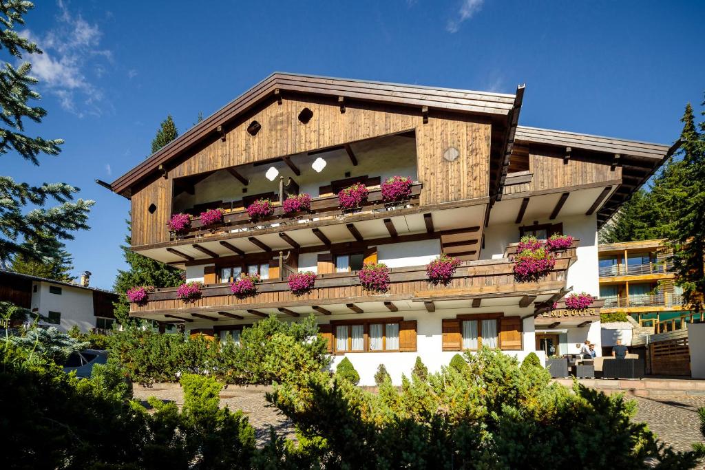 a building with a balcony with flowers on it at Hotel Lajadira & Spa in Cortina dʼAmpezzo