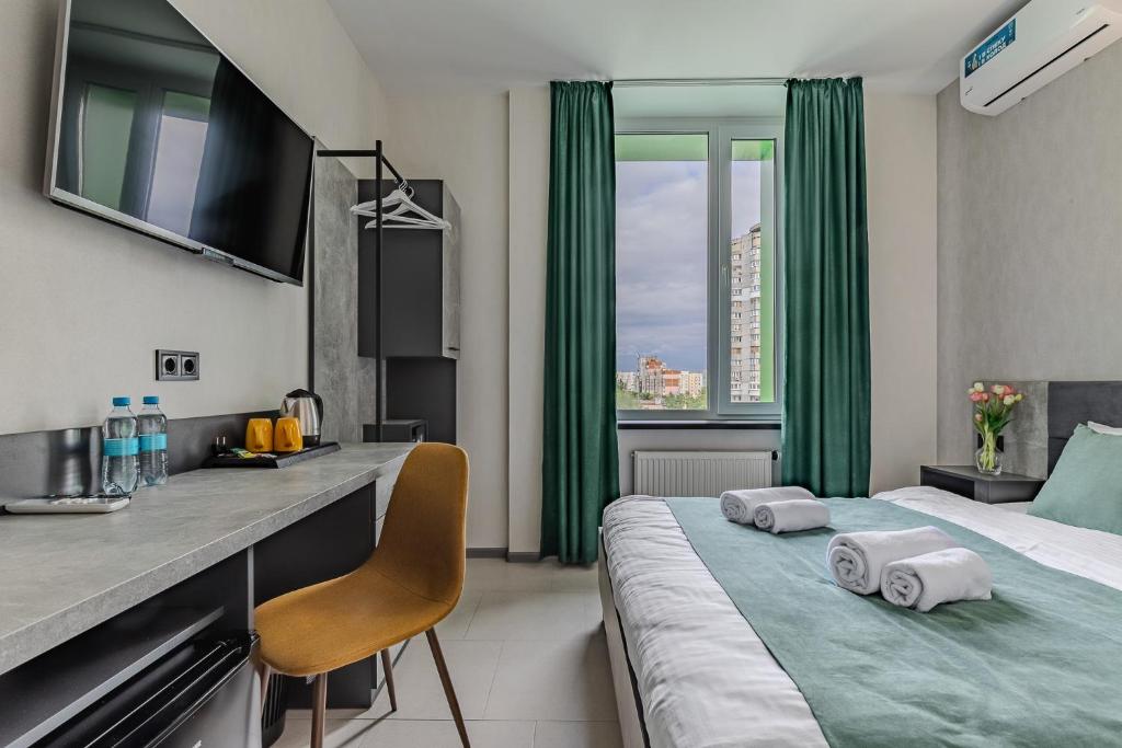 um quarto de hotel com uma cama com cortinas verdes em Green Line Hotel em Kiev