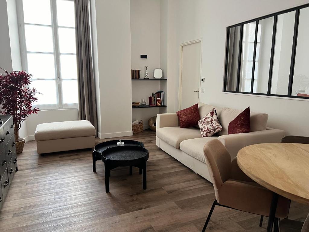 ein Wohnzimmer mit einem Sofa und einem Tisch in der Unterkunft Le Laurencin Sens - Le Peachy in Sens