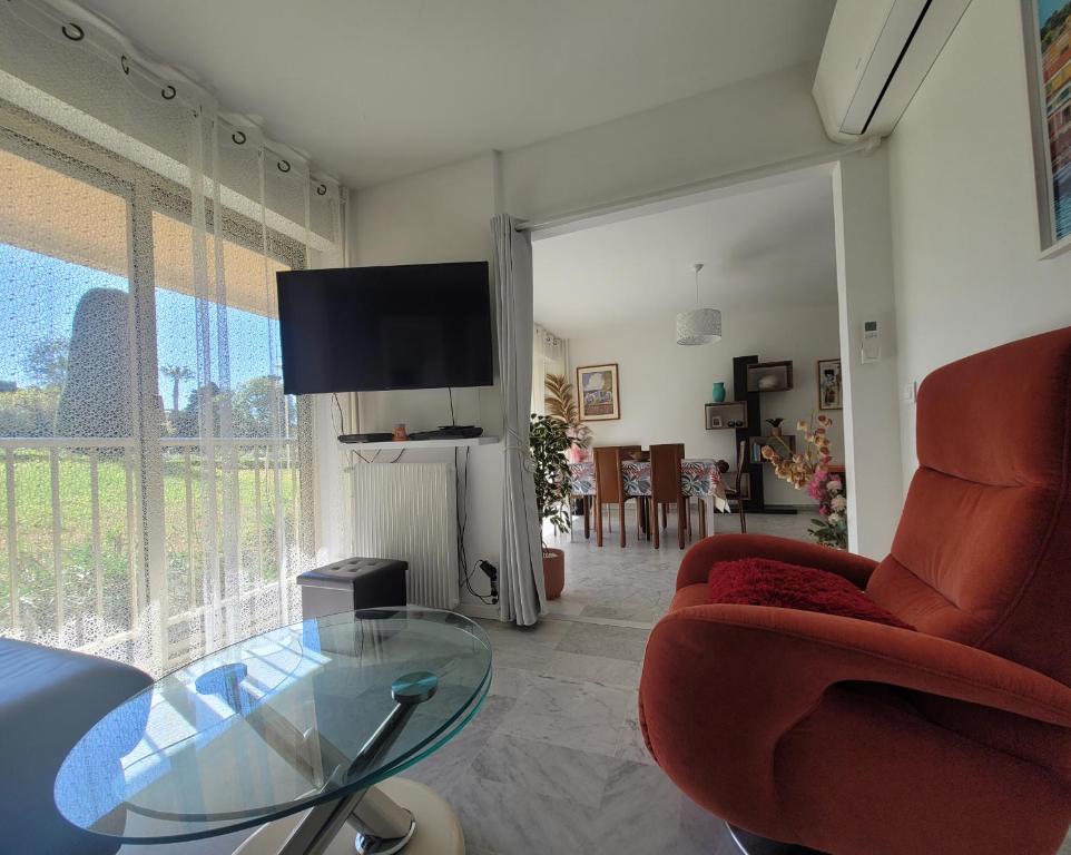 un salon avec une table en verre et une télévision dans l'établissement EDEN PARK T3, à Antibes