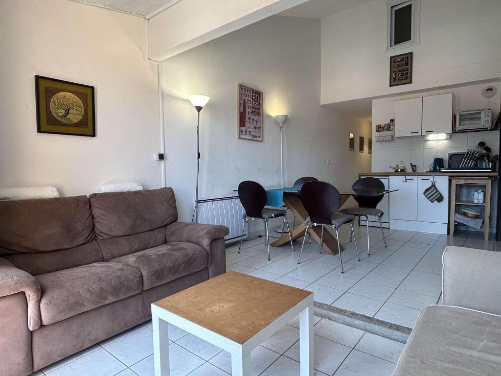 un salon avec un canapé et une table et une cuisine dans l'établissement Duplex 3 pièces climatisé avec parking, proche plage à Banyuls - FR-1-225C-143, à Banyuls-sur-Mer