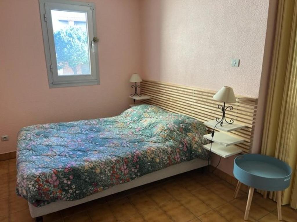 une petite chambre avec un lit et une fenêtre dans l'établissement Appartement T2 avec Garage à Proximité des Plages et Attractions - FR-1-749-65, au Cap d'Agde