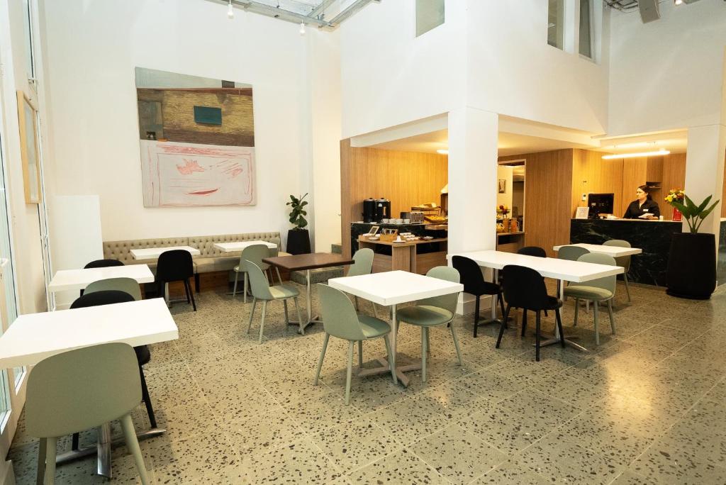 Vain Boutique Hotel في بوينس آيرس: مطعم فيه طاولات وكراسي في الغرفة