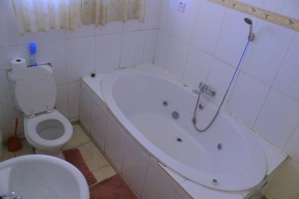 bagno con vasca bianca e servizi igienici di The upperroom bed and breakfast a Francistown