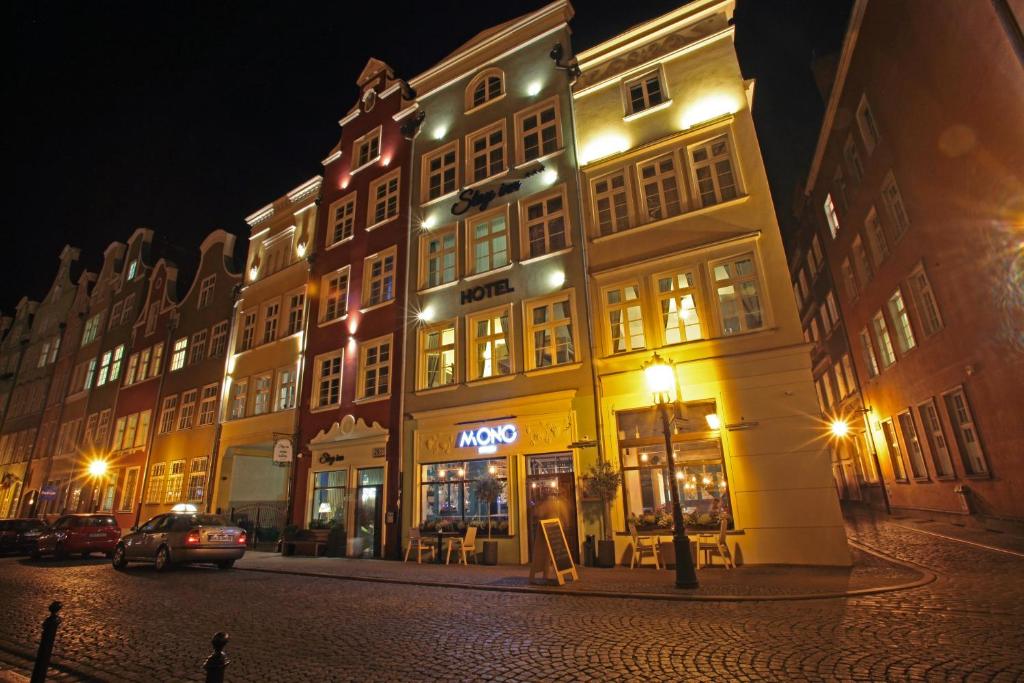 a city street at night with tall buildings at Stay Inn Hotel in Gdańsk