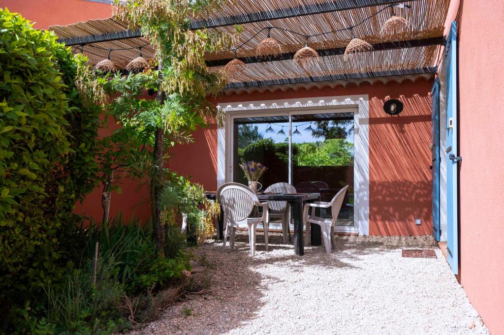 d'une terrasse avec une table et des chaises à l'extérieur d'une maison. dans l'établissement Le Mas de l'Aven, à Aups