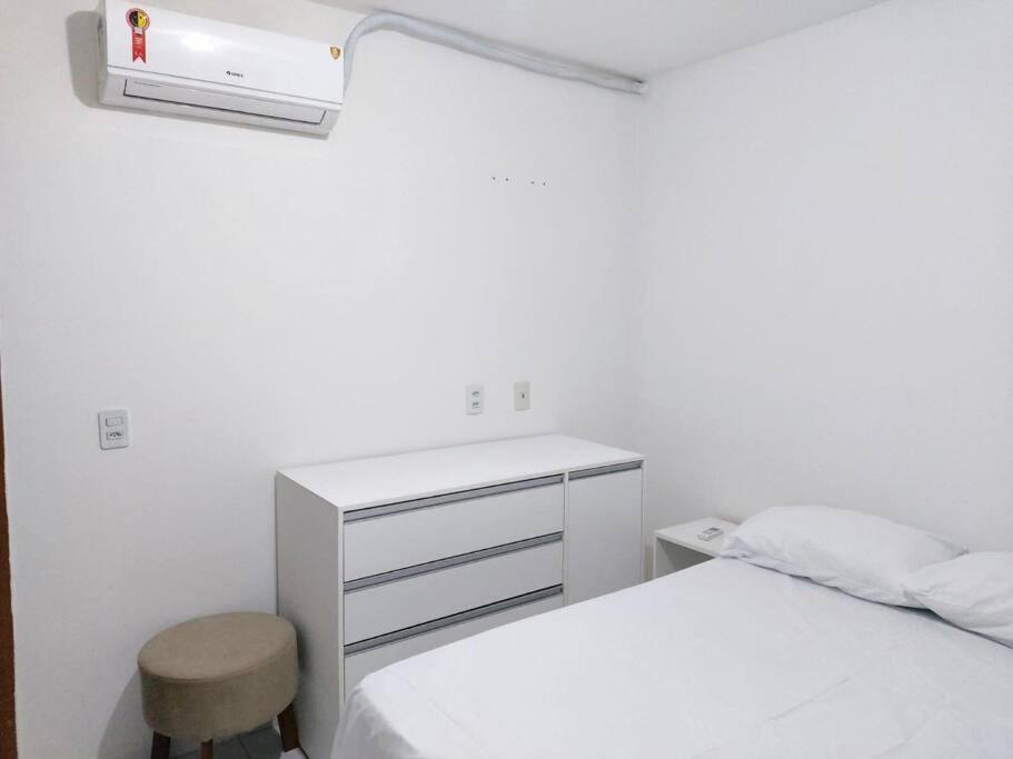 卡魯阿魯的住宿－Apto Ipojuca Caruaru，白色卧室配有床、书桌和凳子