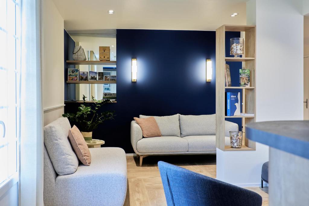 ein Wohnzimmer mit einem Sofa und einem Stuhl in der Unterkunft Quality Hotel La Marebaudière Vannes Centre in Vannes