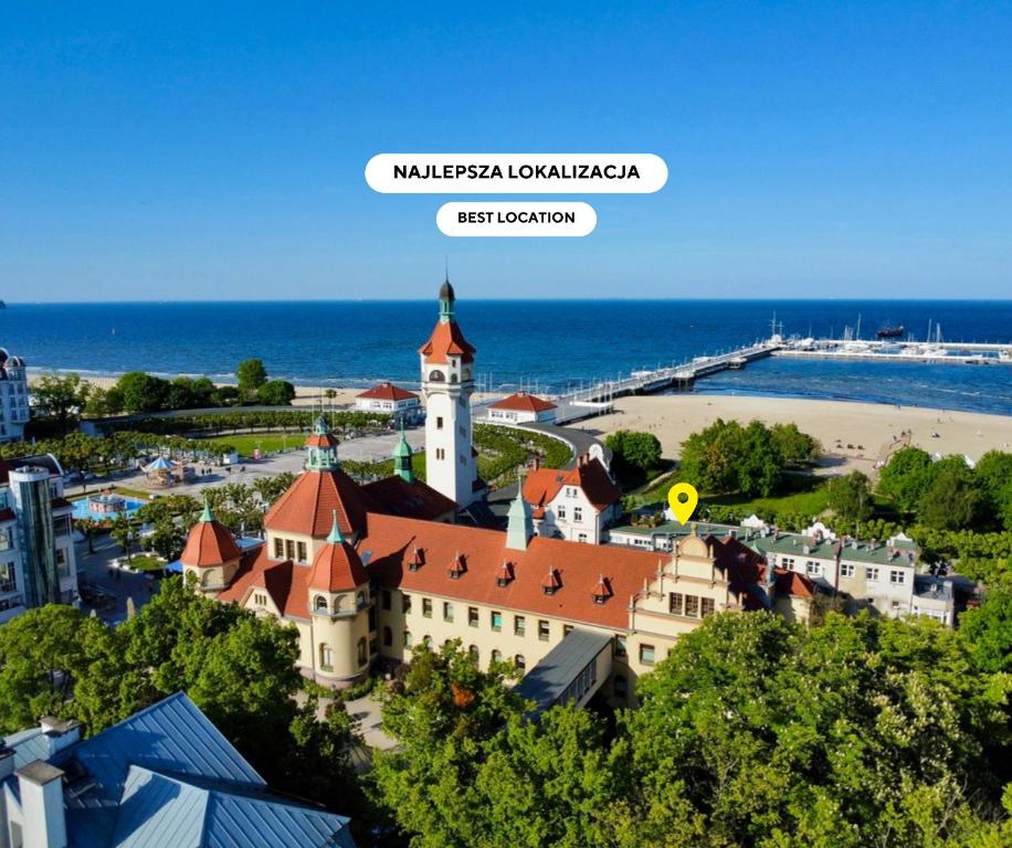 um edifício com uma torre de relógio ao lado de uma praia em SeaSide Sopot - tuż przy plaży em Sopot