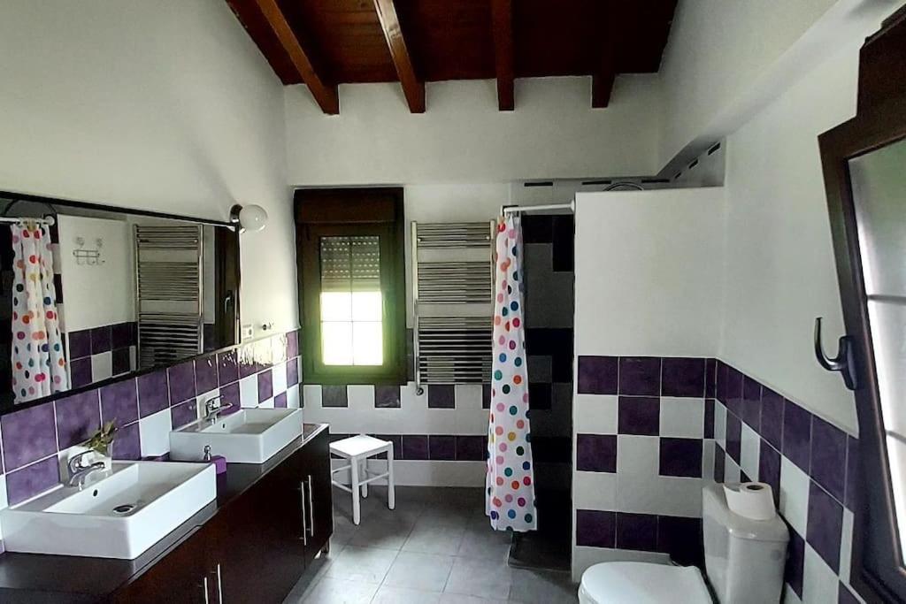 a bathroom with two sinks and two mirrors at La casina in Vega del Ciego