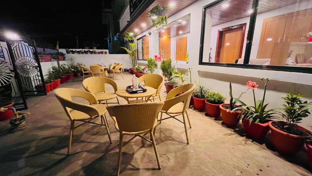 a restaurant with tables and chairs and potted plants at Gulmarg Residency in Mount Ābu