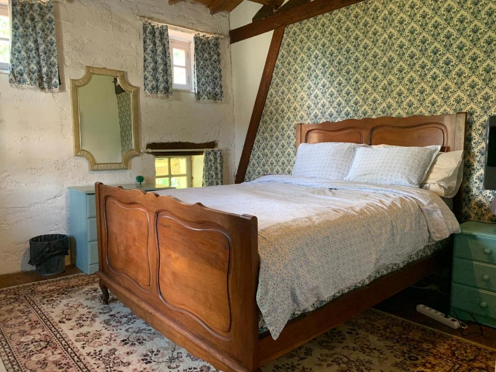 een slaapkamer met een houten bed met een houten frame bij Maison des Roses in Saint-Savinien