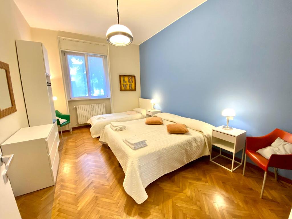 um quarto com uma cama grande e uma cadeira vermelha em Como city apartment Giulio Cesare-private parking em Como