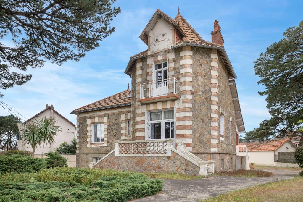 une vieille maison en pierre avec une tour d'horloge dans l'établissement Maison familiale pour 8 proche plage et bourg à St Brévin, à Saint-Brévin-les-Pins