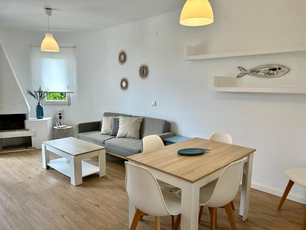 a living room with a table and a couch at Sa Posta in Cala en Forcat